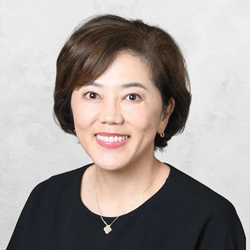 Dr. Narita is wearing a black blouse and a necklace