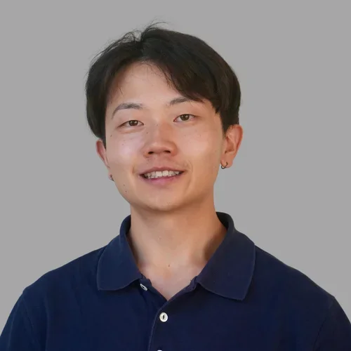 Nathan Fok in a blue polo shirt against a gray backgrond.