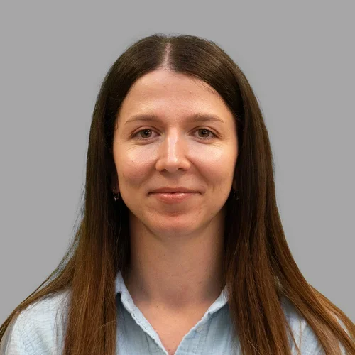 Dr. Maria Cook is wearing a denim collared shirt.