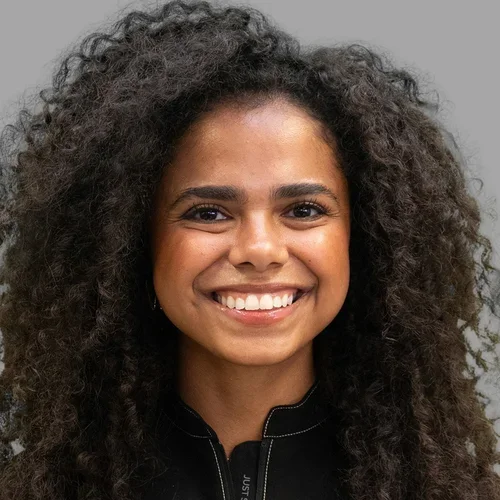 Dr. Mabelitza Guzman Cordero is dressed in black medical scrubs.