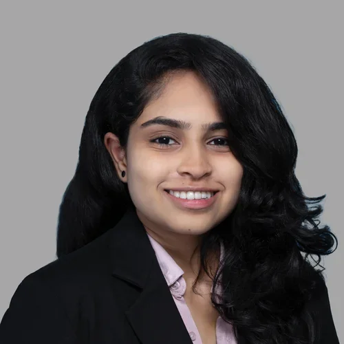 Dr. Geeta Bhuvanagiri is wearing a black blazer over soft lavender button-up shirt.