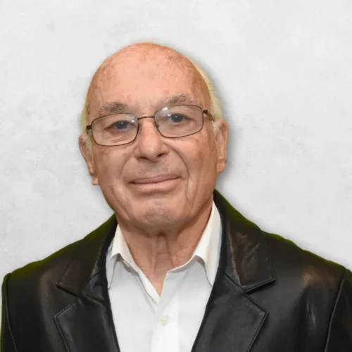 Sigmund Abelson is wearing a black jacket over a white shirt.