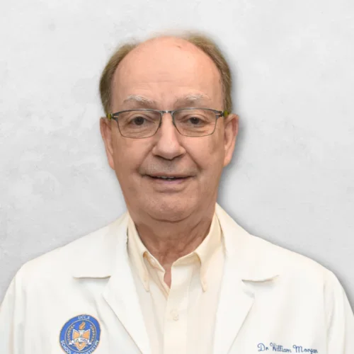 Dr. Morgan is wearing a white doctor's coat over a white shirt.