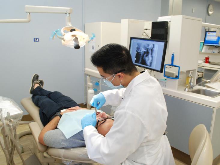 Student dentist in a clinic working on a patient