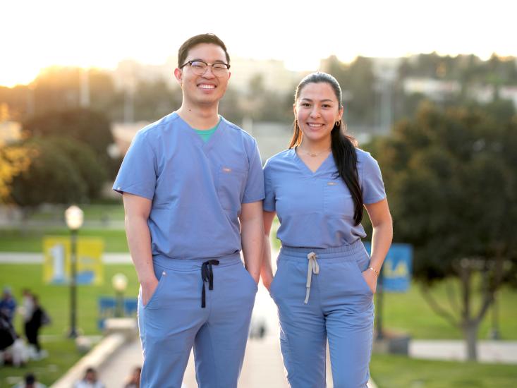 Two dental students smiling at top of steps