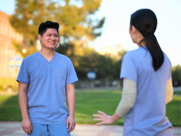 two ucla dental students smiling and conversing at UCLA
