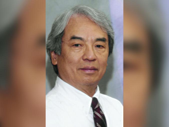 Dr. Thomson Sun wearing a white dress shirt and tie