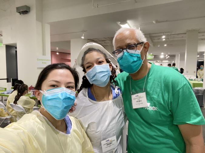 Two UCLA Dentistry students pose in masks with Dr. Edmond Hewlett, at right
