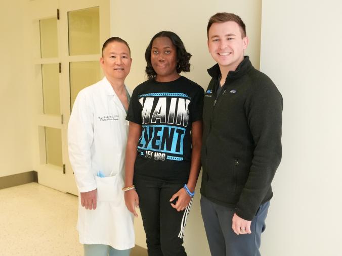 three people posing in a medical center