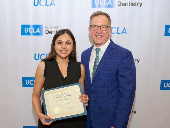 Paul Krebsbach, at left, presents an award to a dental student.