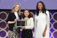 yvonne hernandez kapila accepting the Ross Award from two presenters.