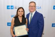 Paul Krebsbach, at left, presents an award to a dental student.