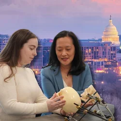 Amy Banks and Janice Lee reviewing craniofacial model with U.S. Capitol in background.