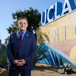 Francisco Ramos-Gomez standing in front of Venice clinic signage, representing community-based dental care and access to care initiatives.