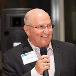 Mark Lisagor wearing a UCLA Dentistry badge and addressing an audience, representing leadership, fundraising, or professional engagement in dentistry.