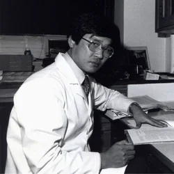 Archival photo of young No-Hee Park reviewing notes at a desk, illustrating early career dental practice and academic training.