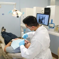 Student dentist in a clinic working on a patient