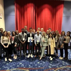 Group photo, with person at center holding an award