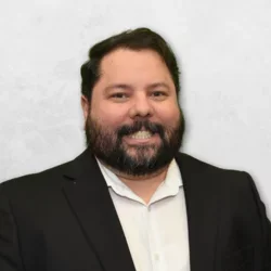 Dr. Radiac is wearing a black suit jacket over a white shirt.