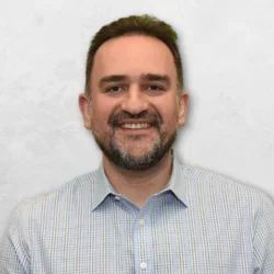 Amir H. Assefnia is wearing a blue and white shirt and has short brown hair.