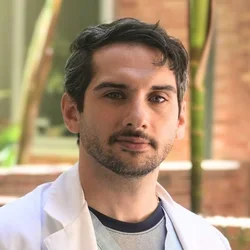 Dr. Antonio Atte in front of a garden wth red brick