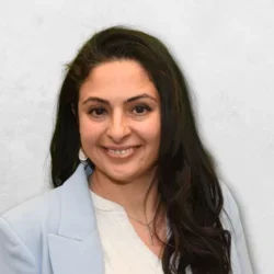 Ayleen R. Peterson is wearing a light blue blazer and has long dark brown hair.