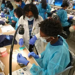 dentist instructing a high school student in the simulation lab