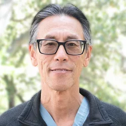 Dr. Sung is wearing a black jacket over medical scrubs.