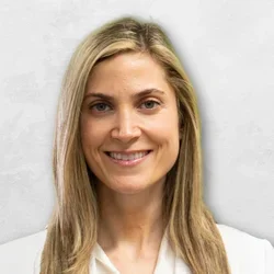 Dr. Erika Kohanof is dressed in a white medical coat layered over a white blouse.