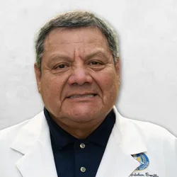 Dr. Bonilla is wearing a dental coat featuring the UCLA Dental Seal, paired with a black collared shirt.