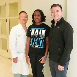three people posing in a medical center
