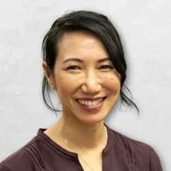 Dr. Helene Shen is wearing a brown V-neck blouse.