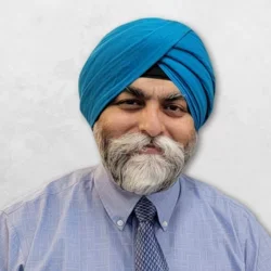 Kanwar Deep Singh Sachdeva is wearing a blue shirt with a tie and a light blue turban.