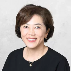 Dr. Narita is wearing a black blouse and a necklace