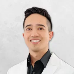 Michael Tuan Hoang is wearing a white doctor's coat over a black shirt.