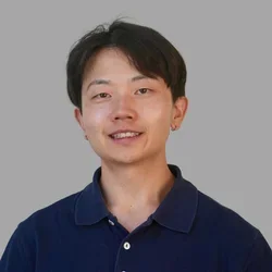 Nathan Fok in a blue polo shirt against a gray backgrond.