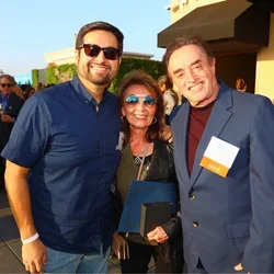 Three people smiling at an outdoor event