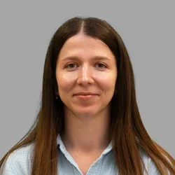 Dr. Maria Cook is wearing a denim collared shirt.