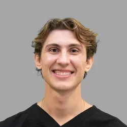 Dr. Matthew Fasulo is dressed in black medical scrubs.