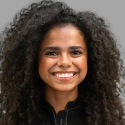 Dr. Mabelitza Guzman Cordero is dressed in black medical scrubs.