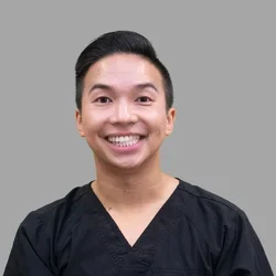 Dr. Matthew Nguyen is dressed in black medical scrubs.