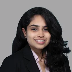 Dr. Geeta Bhuvanagiri is wearing a black blazer over soft lavender button-up shirt.