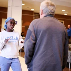 A dental student speaks with a patient in the clinic’s main waiting area.