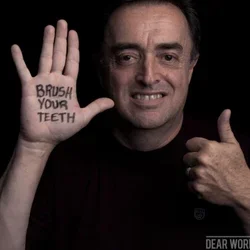 Ramos-Gomez holding up hand with words "Brush Your Teeth" on his palm.