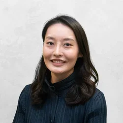 Sally Rhee is waring a dark blue blouse.