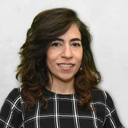 Dr. Angha is wearing a pin black shirt with white and gray strips.