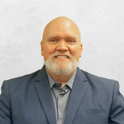 Jason Struwe is wearing a suit jacket over a collar shirt.