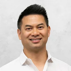 Dr. Arroyo is wearing a white button-up collared shirt.