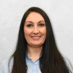 Vanessa porter has long dark hair and is wearing a light blue shirt.