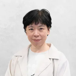 Dr. Wei is wearing a crisp white jacket paired with a white shirt that has no collar.